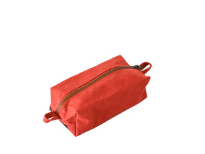 Red toiletry bag with a gold zipper on a white background
