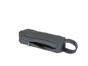 A dark gray fabric pouch with a zippered opening and a loop handle, nomado store.