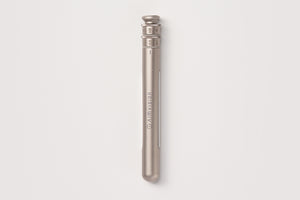 A sleek, metallic titanium gold pen with engraved branding and a textured top cap, shown vertically against a clean, light gray background.