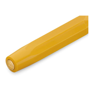 A close-up of a yellow hexagonal pen barrel with a gold-toned tip, shown on a clean white background.