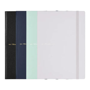 Four mnemosyne notebooks in different colors (black, navy, mint green, and white) arranged side-by-side to show their textured covers and elastic closure bands.