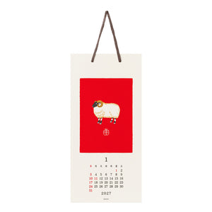 A hanging wall calendar page for January 2027 with a cream background, a large red square featuring a stylized sheep illustration, and a small monthly calendar grid at the bottom.