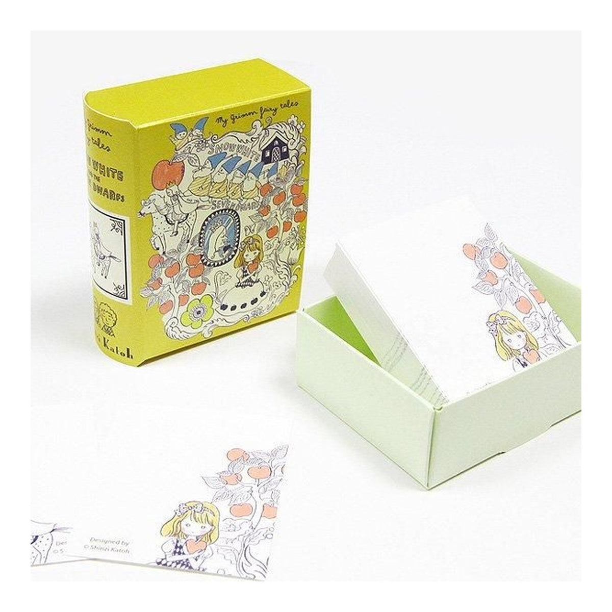 A boxed card deck with illustrated cards shown next to an open box on a white background. The packaging is bright yellow on the outside and pale mint green inside, with white cards featuring pastel line-art illustrations of a girl with orange flowers. Snow white