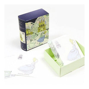 A set of illustrated notes and matching packaging on a white background. The box is dark purple with a whimsical castle illustration, and the sticky notes inside a pale green tray show a girl in a white dress. Cinderella