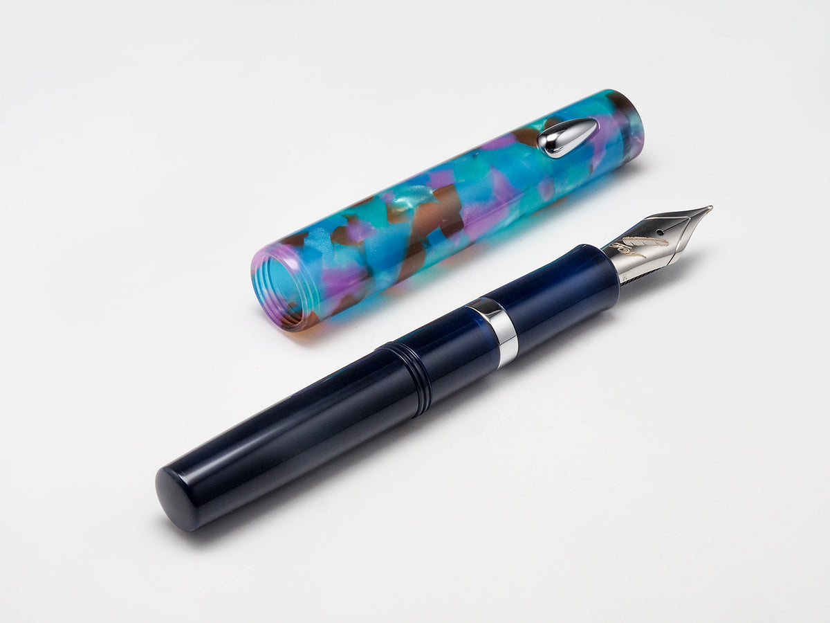 A fountain pen and its cap displayed on a clean white background. The pen body is dark navy blue with a silver band, and the cap features a marbled pattern of blue, purple, and brown.