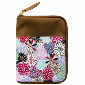 A zippered pouch with a brown top section and a colorful floral patterned lower section, featuring a gold-tone zipper and a brown pull tab, shown on a plain white background.
