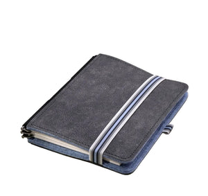A dark blue fabric notebook cover with two white diagonal stripes, shown closed on a light beige background with soft shadows.