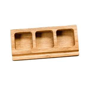 Wooden three-compartment tray on a rustic wooden surface with small metal objects.