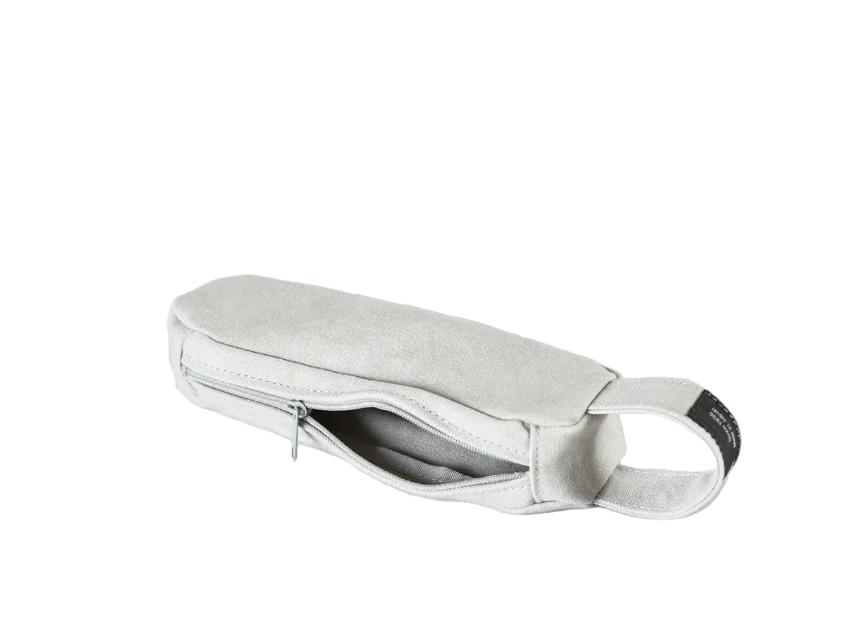 A light gray fabric pouch with a zippered main compartment and a small black label on the side, nomado store.
