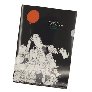 Notebook with black cover featuring white illustrations of  cats and a red balloon.