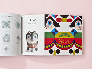 Open book with colorful illustrations of a cat and traditional design on a pink background by Cochae