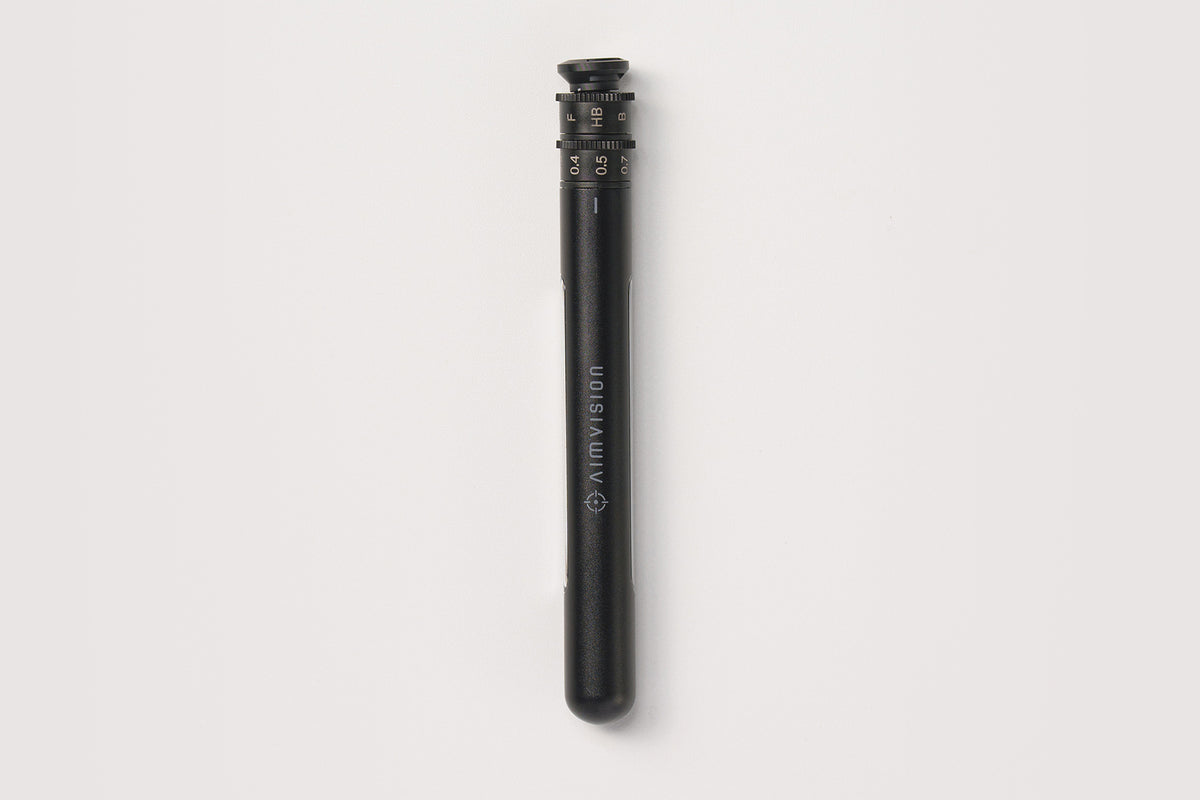 A black cylindrical Klim VISION baton-style accessory with white printed branding, shown vertically against a light gray background.