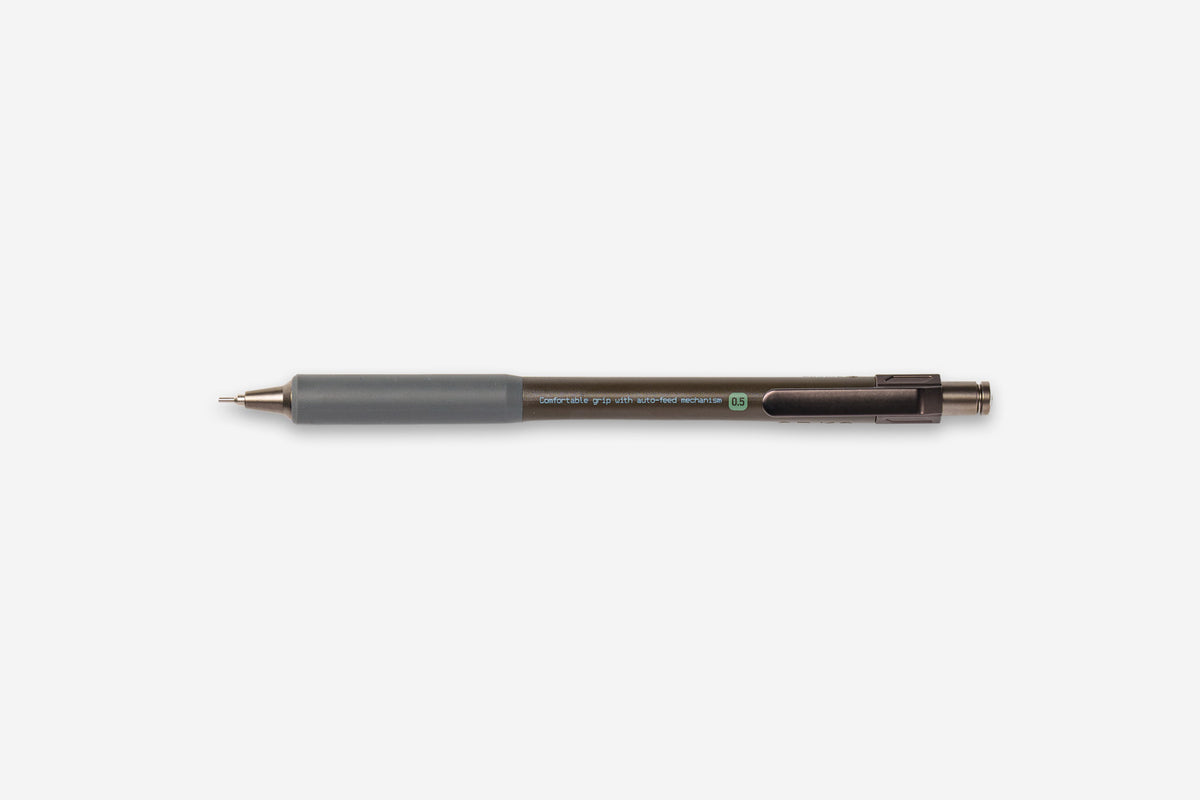 A dark brown retractable ballpoint pen with a matte gray grip, shown horizontally against a plain light gray background.