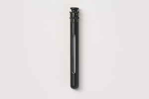 A sleek, matte black cylindrical device with a transparent vertical window showing a blue-gray interior, set against a solid off-white background.