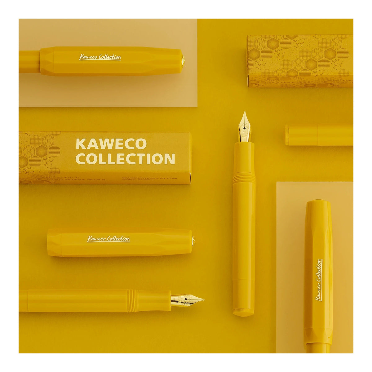 Yellow Kaweco Collection fountain pen components and matching yellow packaging arranged in a flat-lay composition on a yellow background, with one pen nib and cap section shown vertically and the text 'KAWECO COLLECTION' visible on the box.