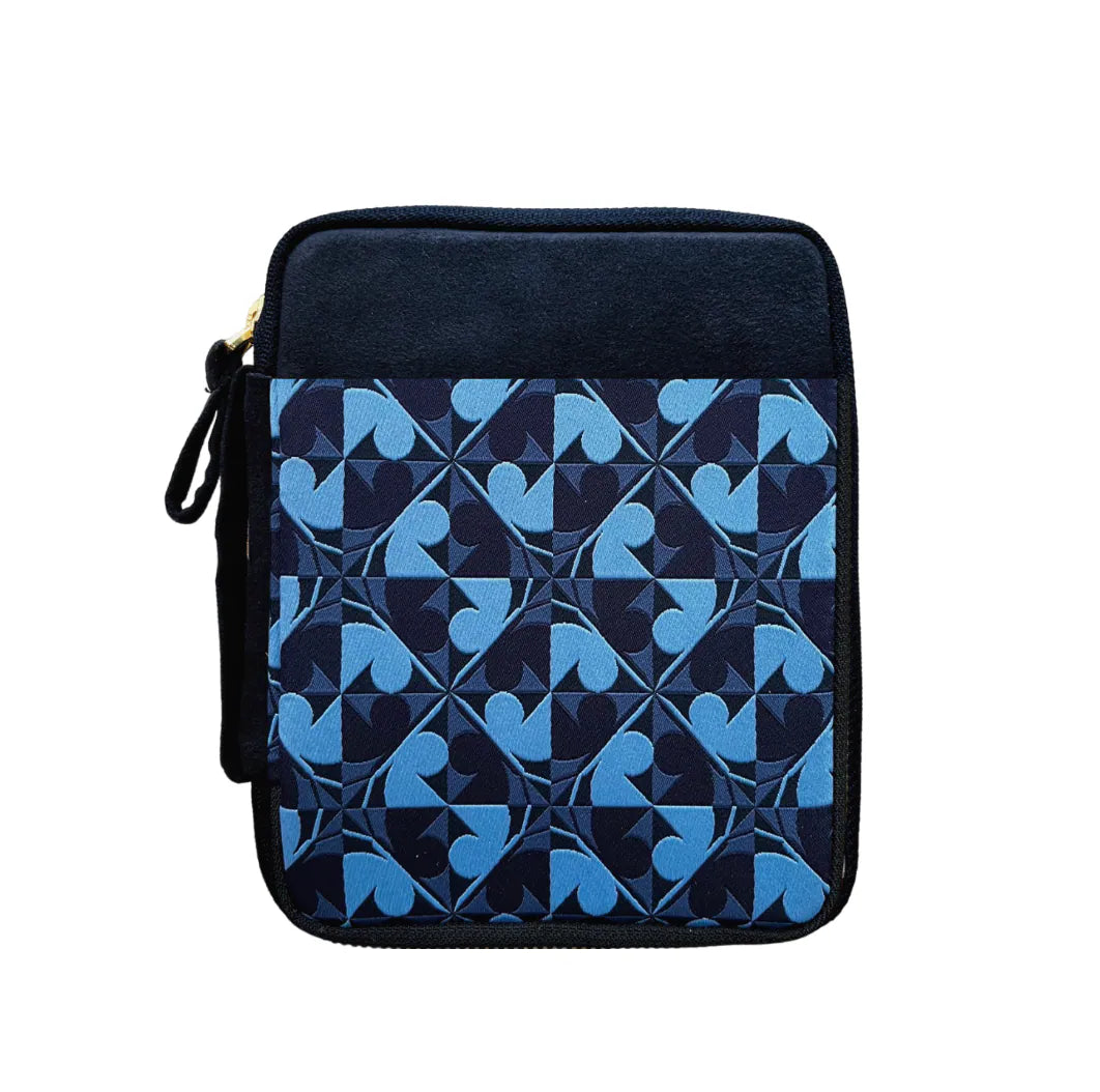 A square zippered pouch featuring a dark navy blue velvet top section and a geometric patterned front panel in shades of blue and navy, with a black zipper pull.
