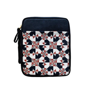 A square tablet sleeve featuring a geometric patterned front panel with navy blue, white, and terracotta red shapes, and a solid navy blue top section with a gold zipper pull.
