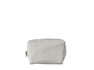 A light gray canvas cosmetic pouch with a top zipper closure, shown on a seamless white studio background.