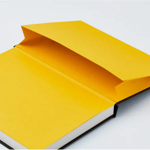 A hardcover notebook or journal shown open at an angle, with a bright yellow cover and white page edges visible against a clean white background.
