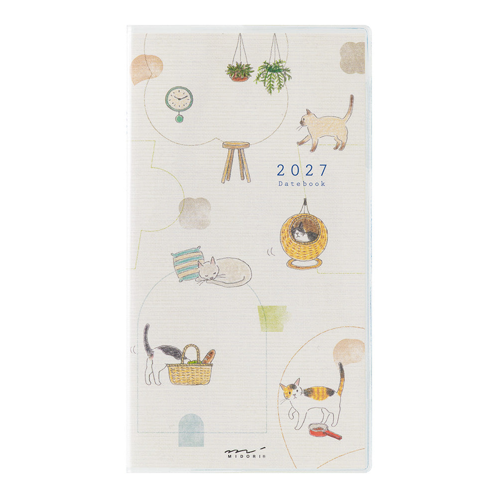 A 2027 daily planner notebook with a cream-colored cover decorated with cute cat illustrations and small doodles, shown against a plain white background.