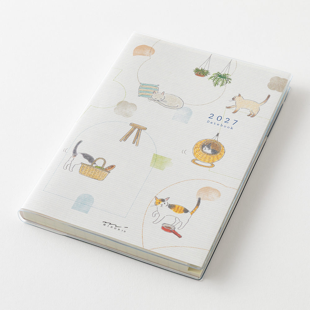 A 2027 daily planner with a white cover decorated with cute, minimalist cat illustrations in soft pastel colors, shown on a clean white background.