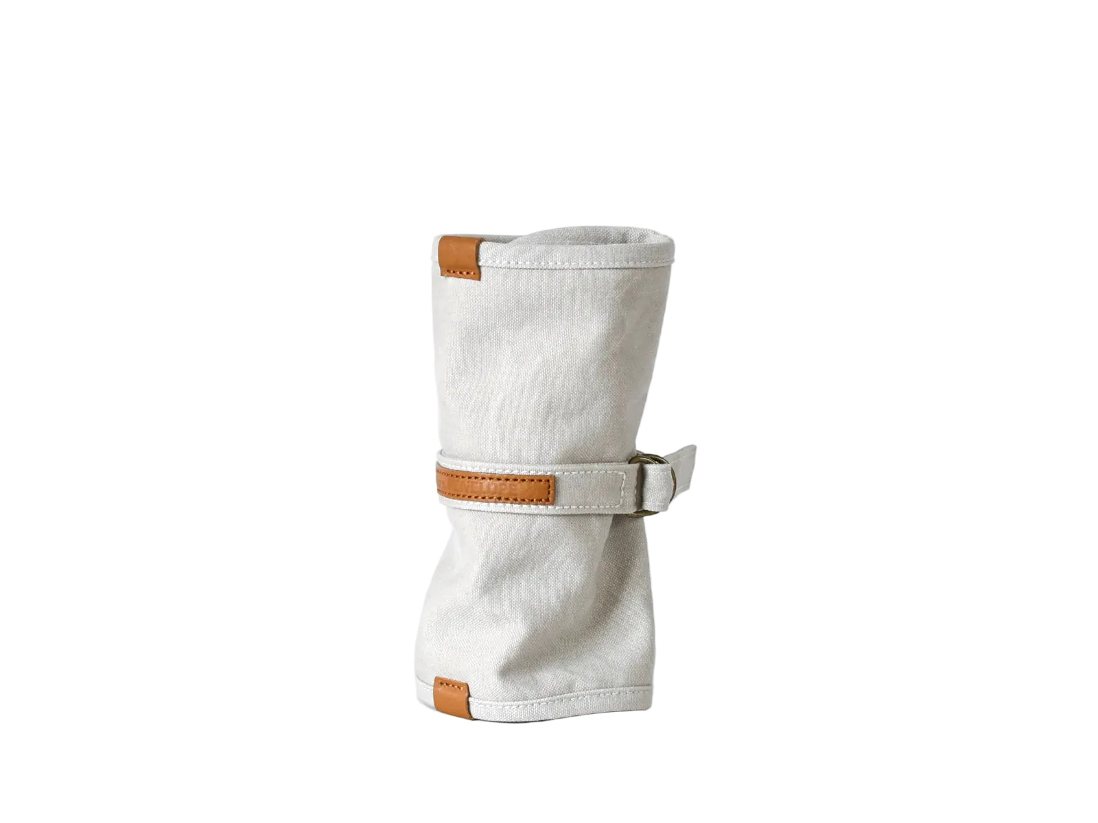 A light beige canvas sleeve with tan leather trim and a matching leather strap closure, standing upright on a white surface against a white background.