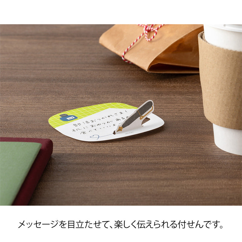 Round coaster with a pen on a wooden surface next to a cup