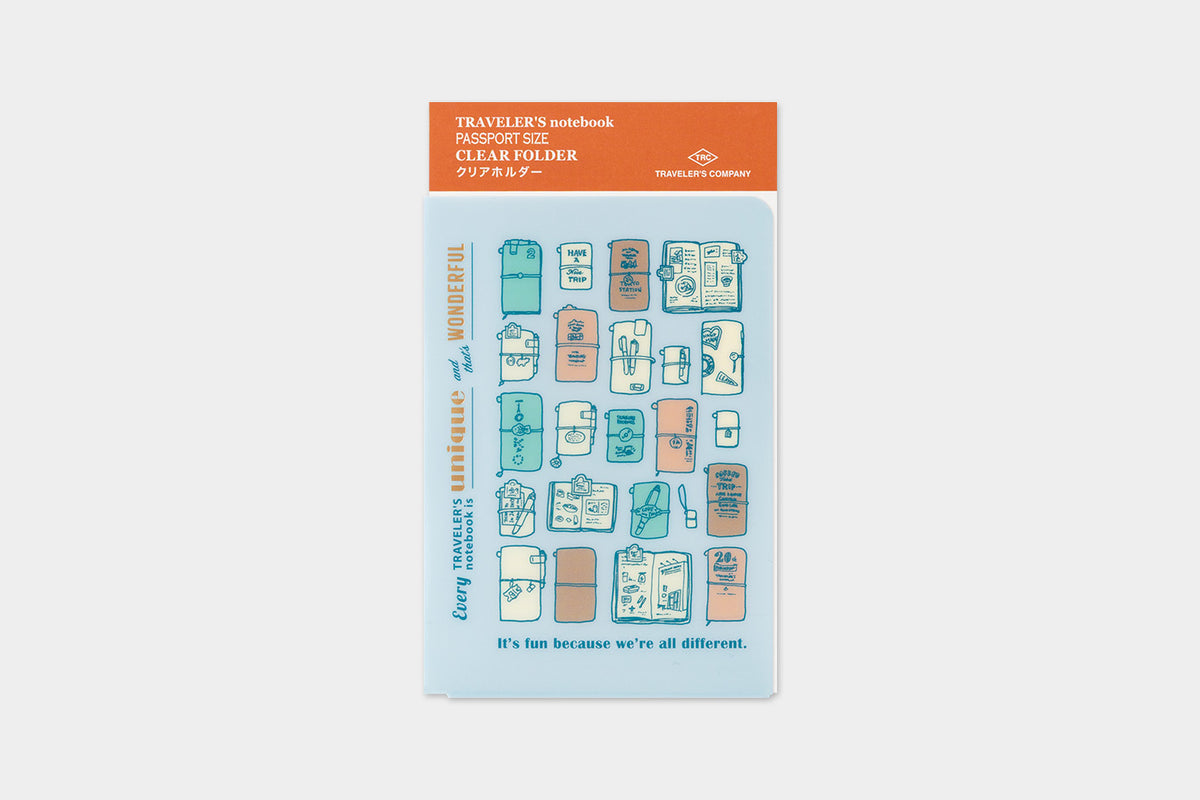 A packaged clear travel notebook folder shown on a light gray background. The top header is orange and reads 'TRAVELERS notebook CLEAR HOLDER,' with a blue card below featuring illustrated travel-themed icons in pastel blue, peach, and orange.